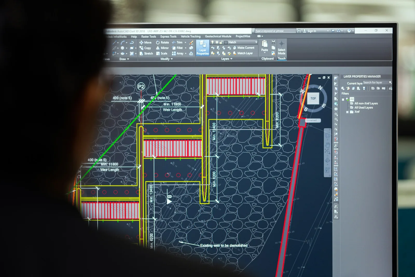 An engineer looking at a CAD drawing on a computer monitor