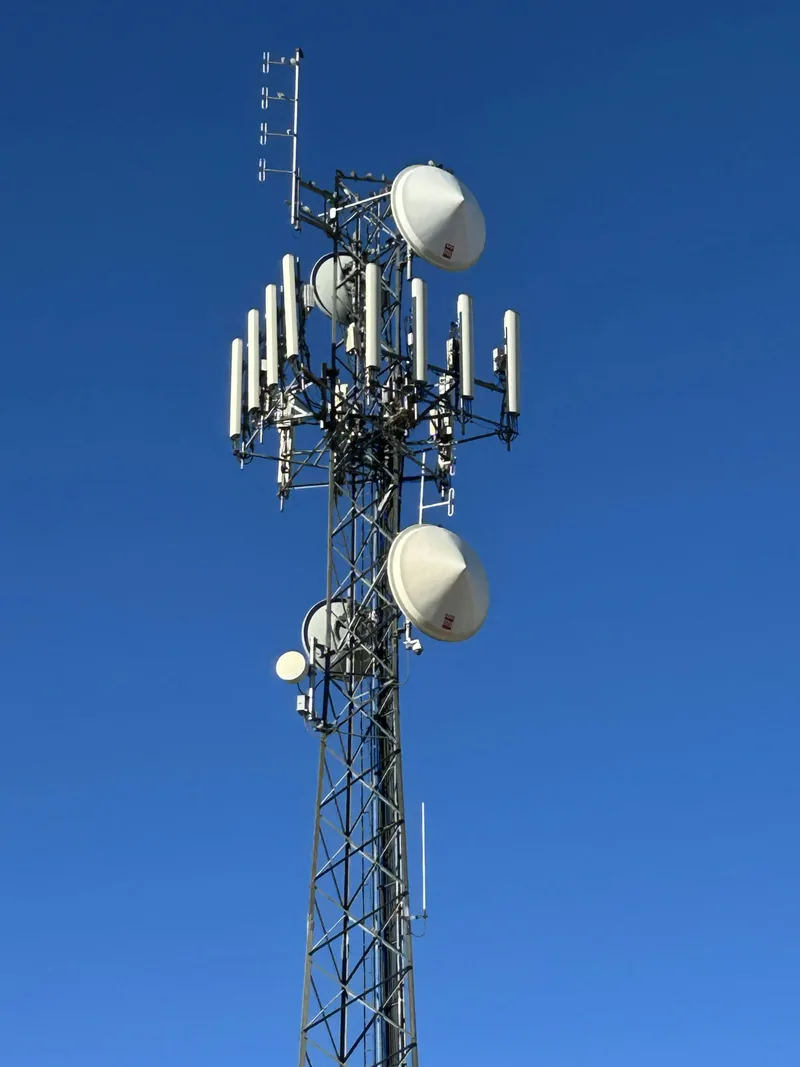 Tall telecommunications tower against a clear blue sky