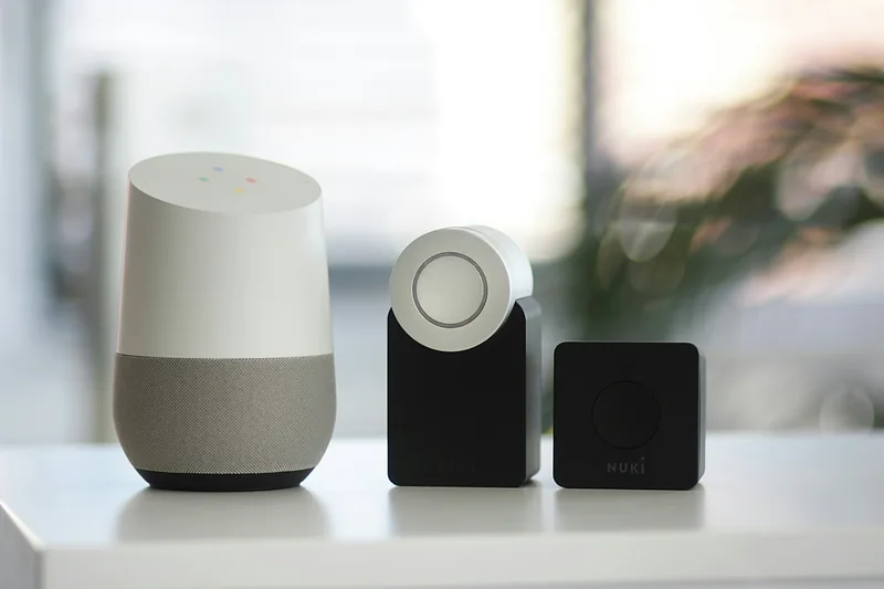 A smart speaker and a smart lock on a white shelf