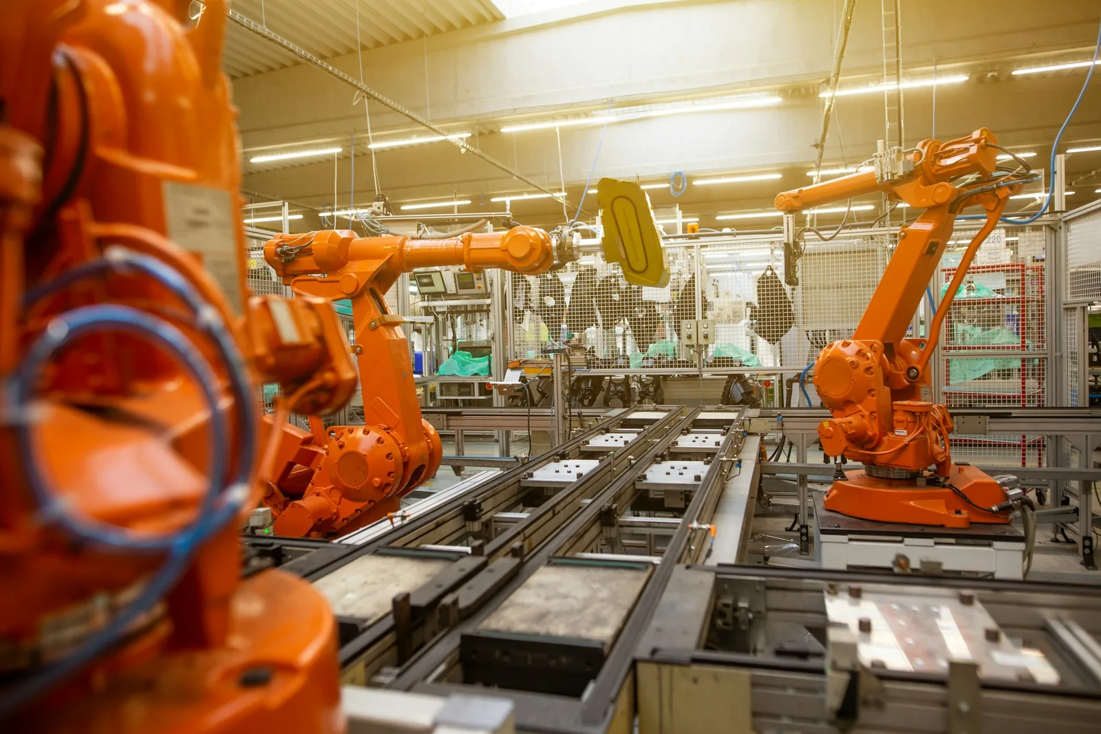 Orange robot arms on an automotive assembly line