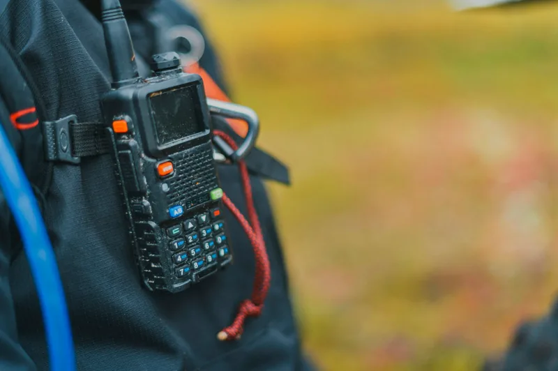 Black two-way radio on a dark strap