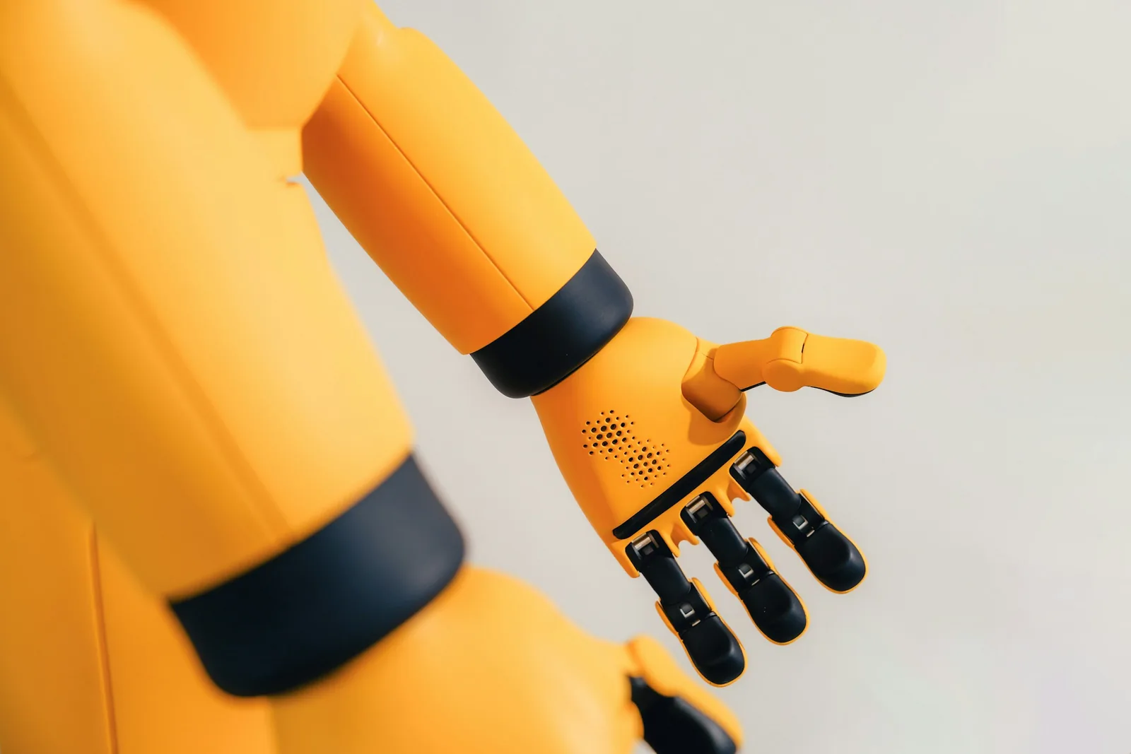 A yellow robotic arm with a mechanical hand
