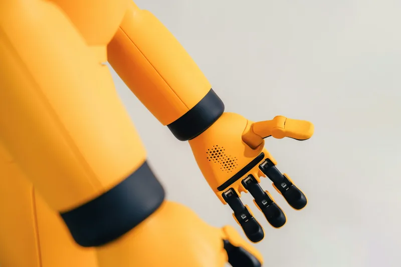 A yellow robotic arm with a mechanical hand